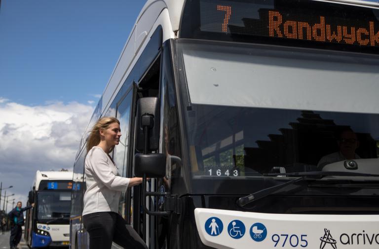 Vrouw stapt bus in