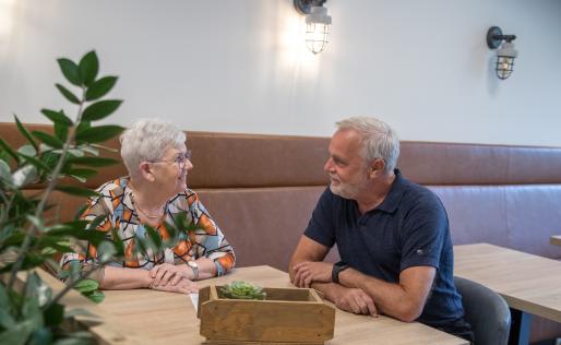 senior vrouw aan tafel in gesprek met man