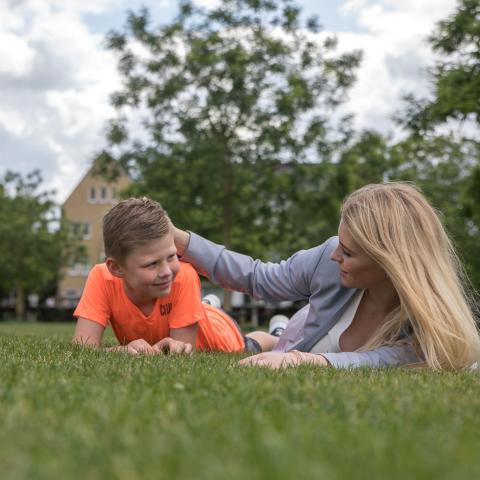 Jongetje en vrouw samen in gras